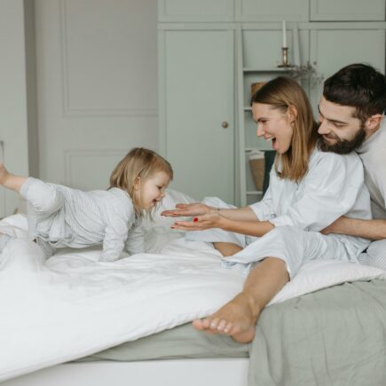 Genitori e bimba felici sul letto