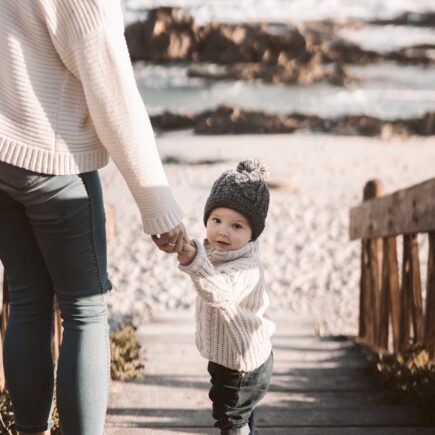 mamma e bambino in spiagga in inverno